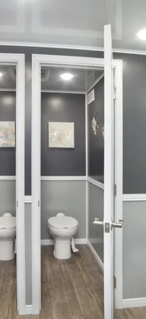 Inside look of bathroom stalls in 10 Station Restroom Trailer